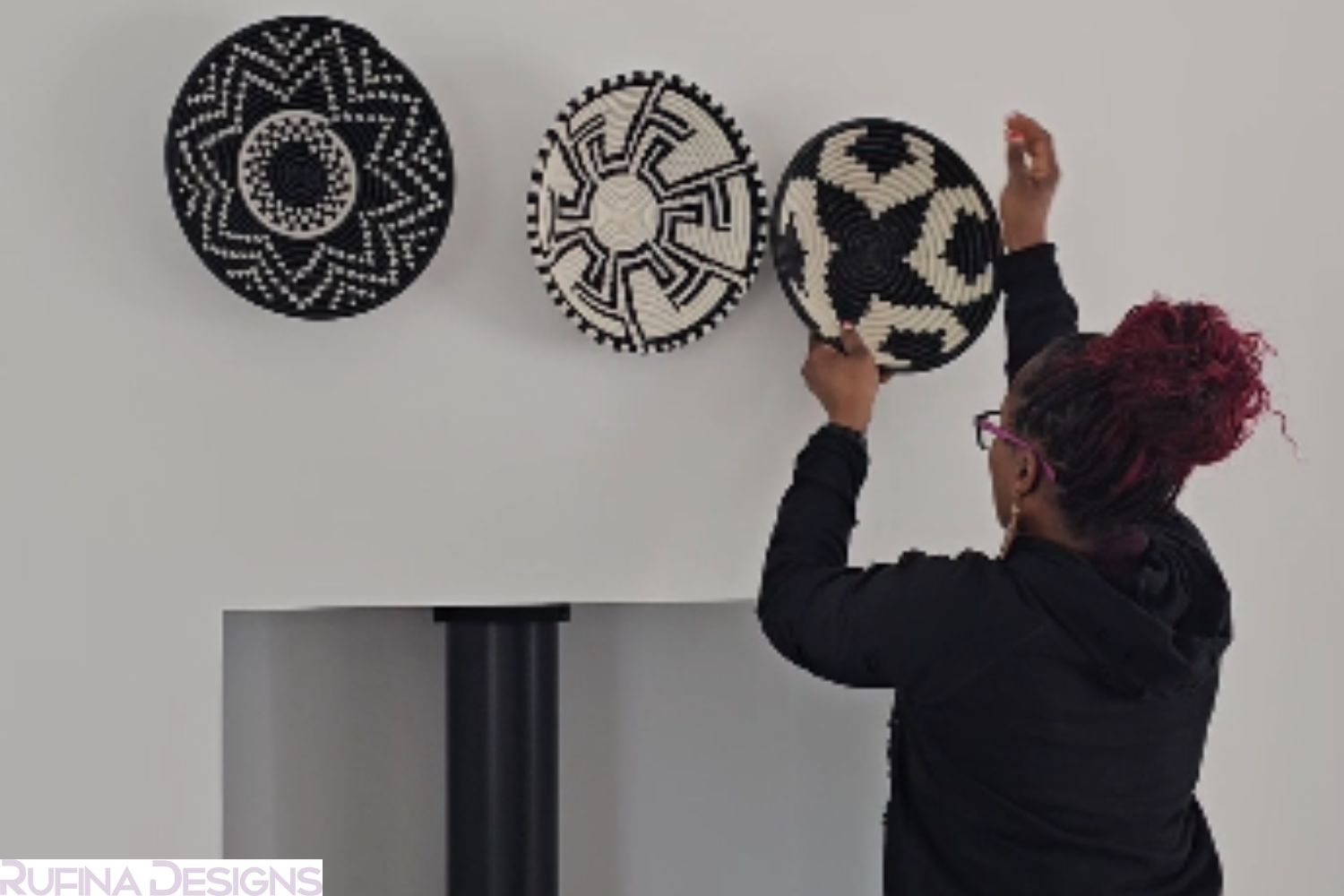 Rufina designing her wall with her baskets